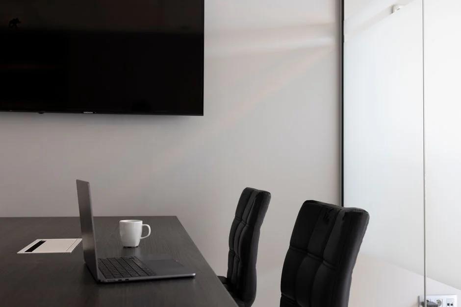 Spacious and contemporary office interior with glass partitions, stylish furniture, and vibrant wall art.
